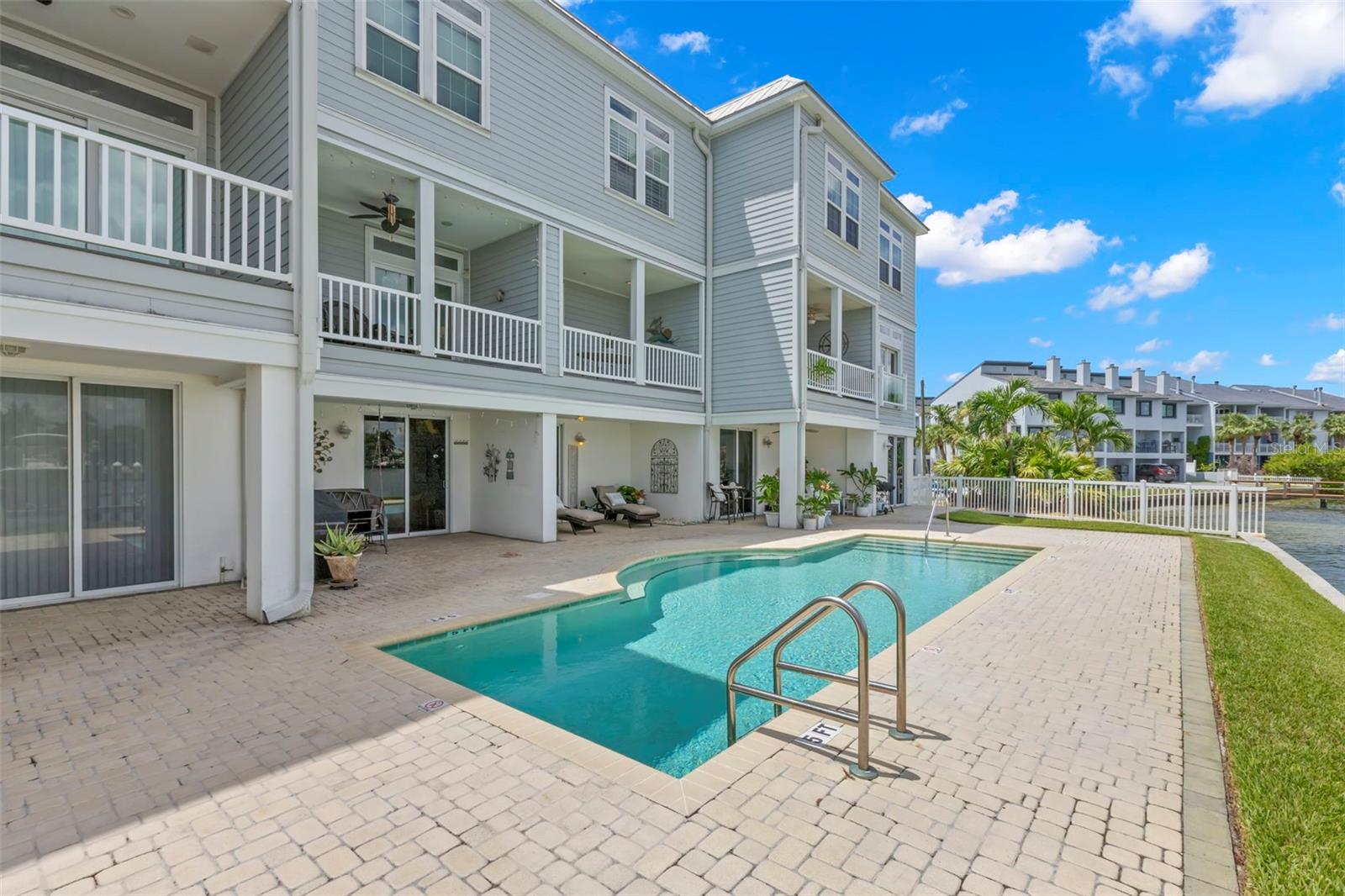 Facing north across the pool, this serene view showcases the charming balconies and inviting outdoor space, perfect for relaxation.