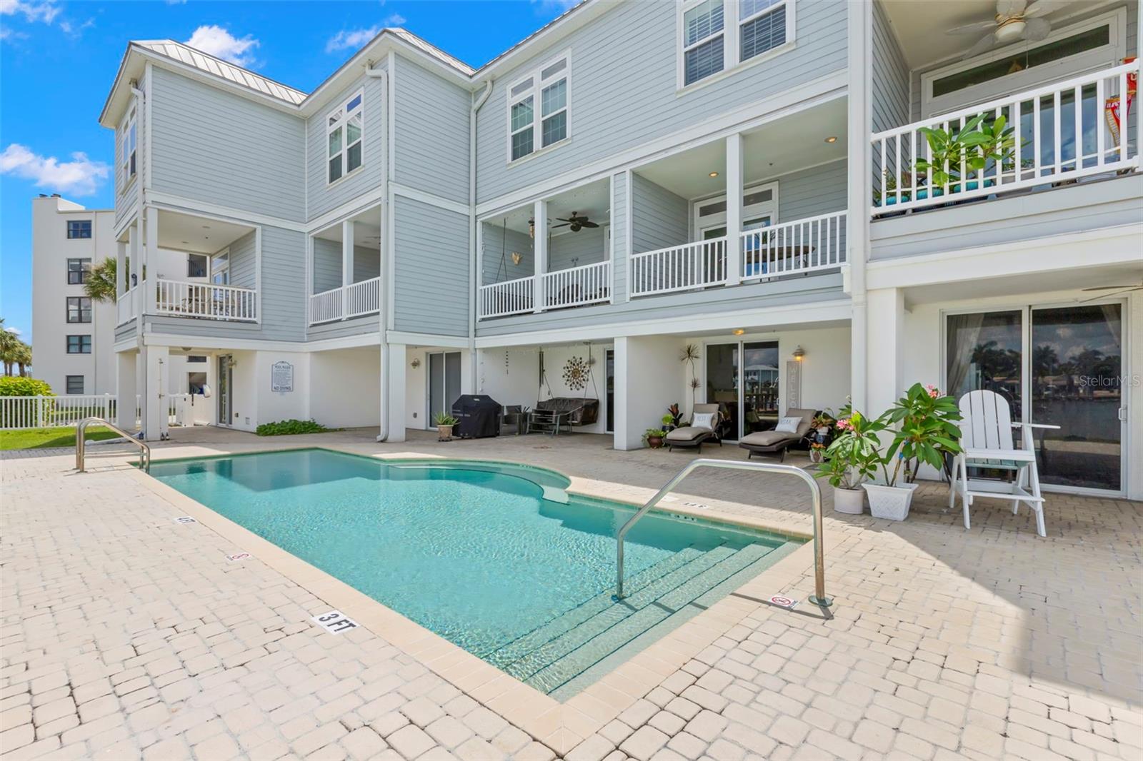 Enjoy the sun by the pool or relax in the shade on your private patio, offering seamless indoor-outdoor living in this beautiful waterfront home.