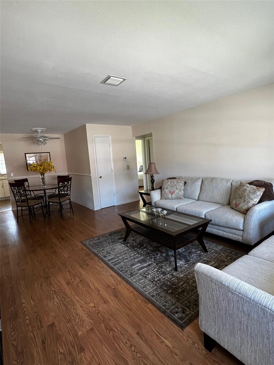 Living/Dining Room with entrance to Kitchen and Den past Dining Room