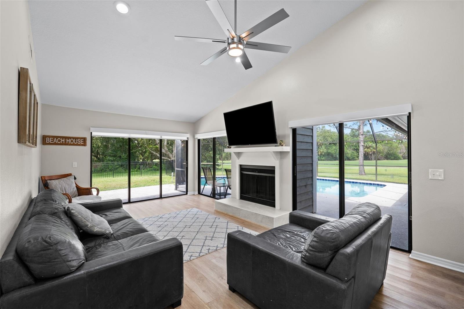 Living room overlooking pool, golf course and backyard lanai