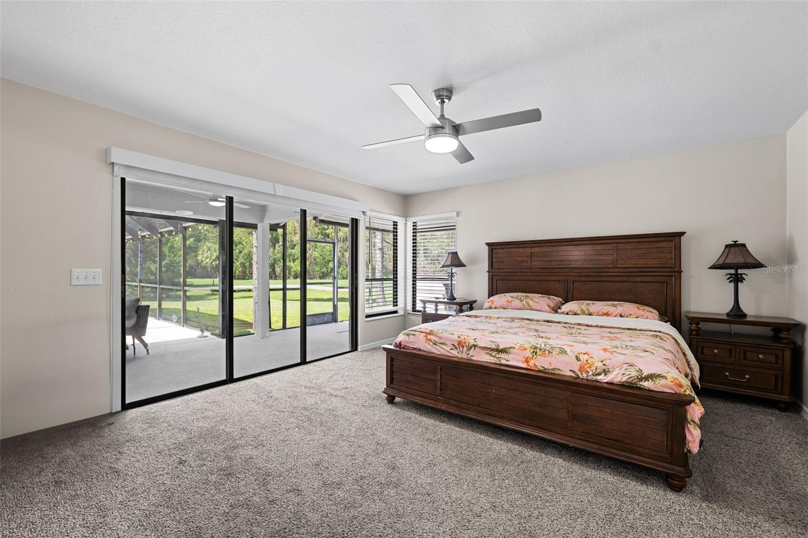 Large Primary Bedroom with sliders to secluded covered lanai and pool area