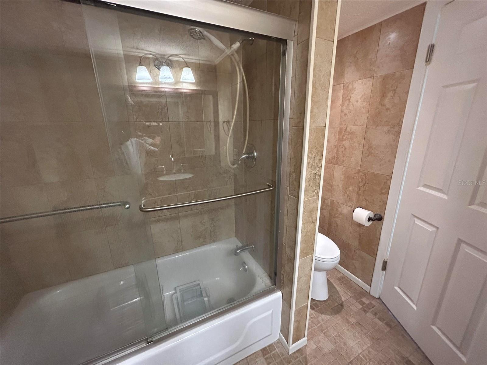 Sliding glass door shower with sperate partition for the toilet area