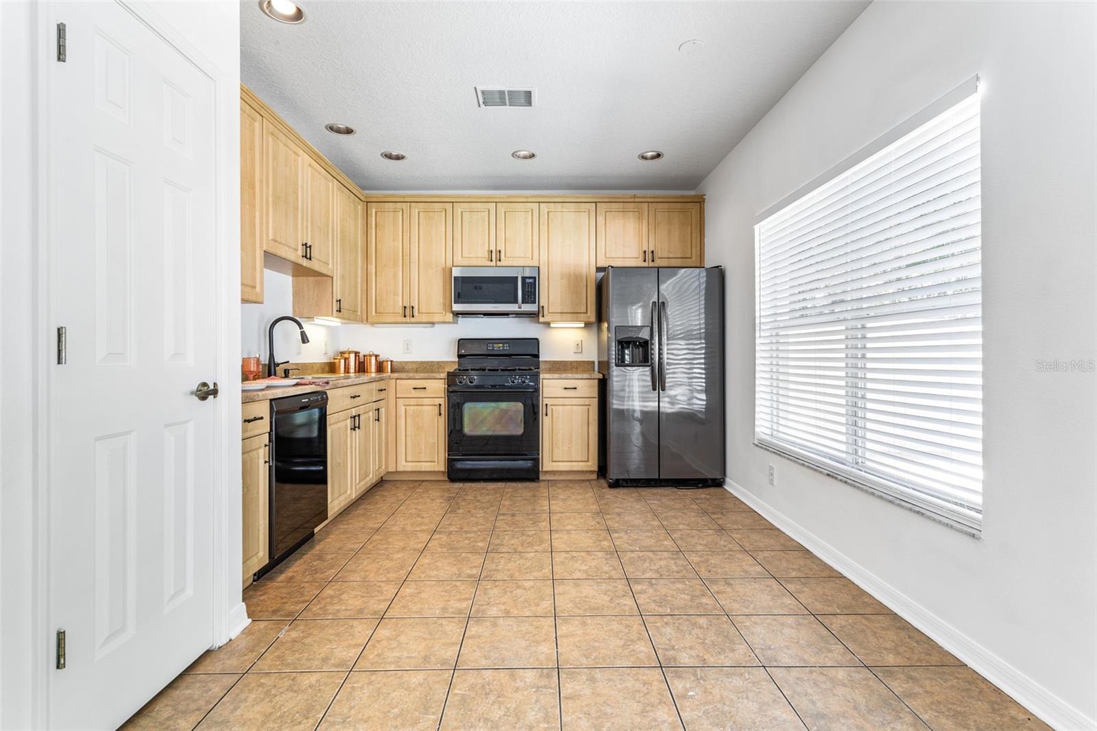 Welcome to the large kitchen and dining room combo. Large tiles for easy cleaning. Lots of cabinets and a pantry. Large window overlooking the backyard. Add an island with a counter for stools for even more space.