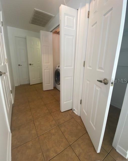 Hallway off of the dining area includes another full pantry, laundry closet, storage room under the stairs and a half bath. Door to the garage at the end.