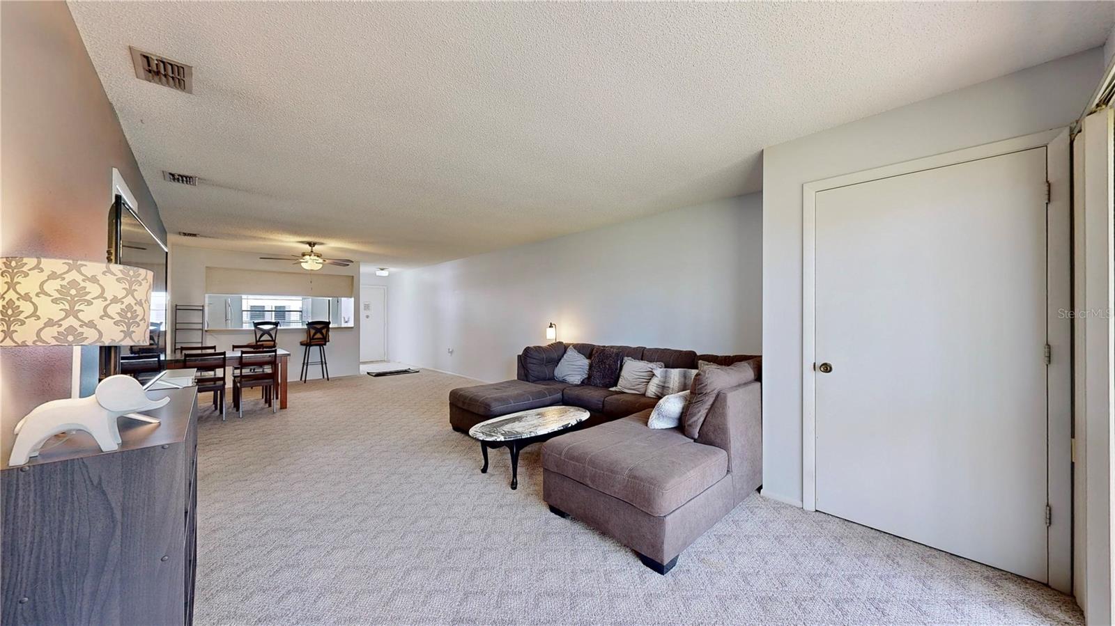 Open living room leads to your beautiful patio overlooking the lush green space with trees.