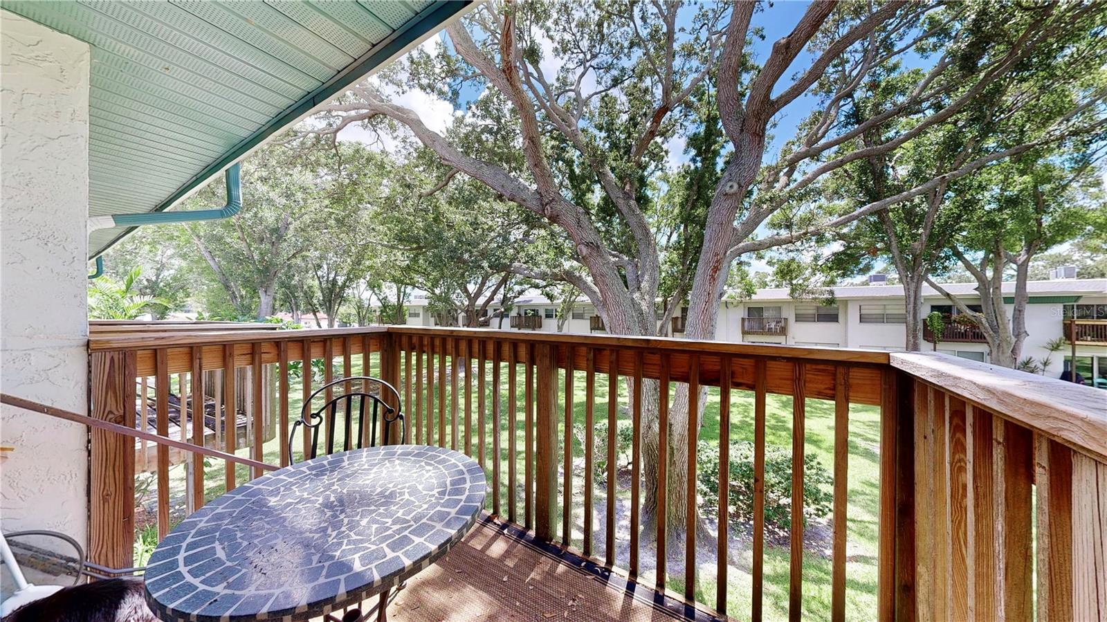 Beautiful patio overlooking the lush green space with trees.