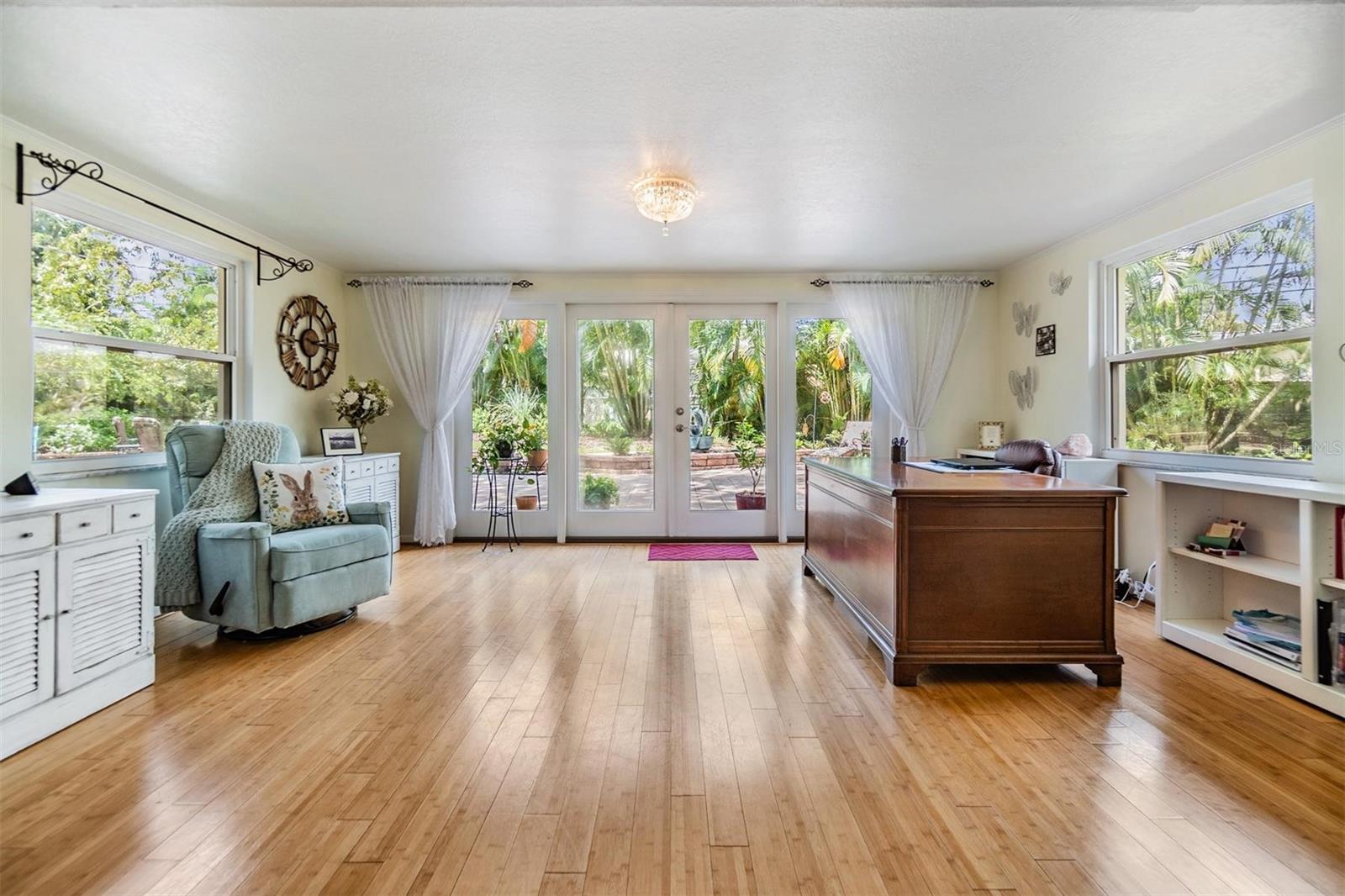 Bright and cherry sunroom with expansive views of tranquil back yard and French doors out to back yard oasis.