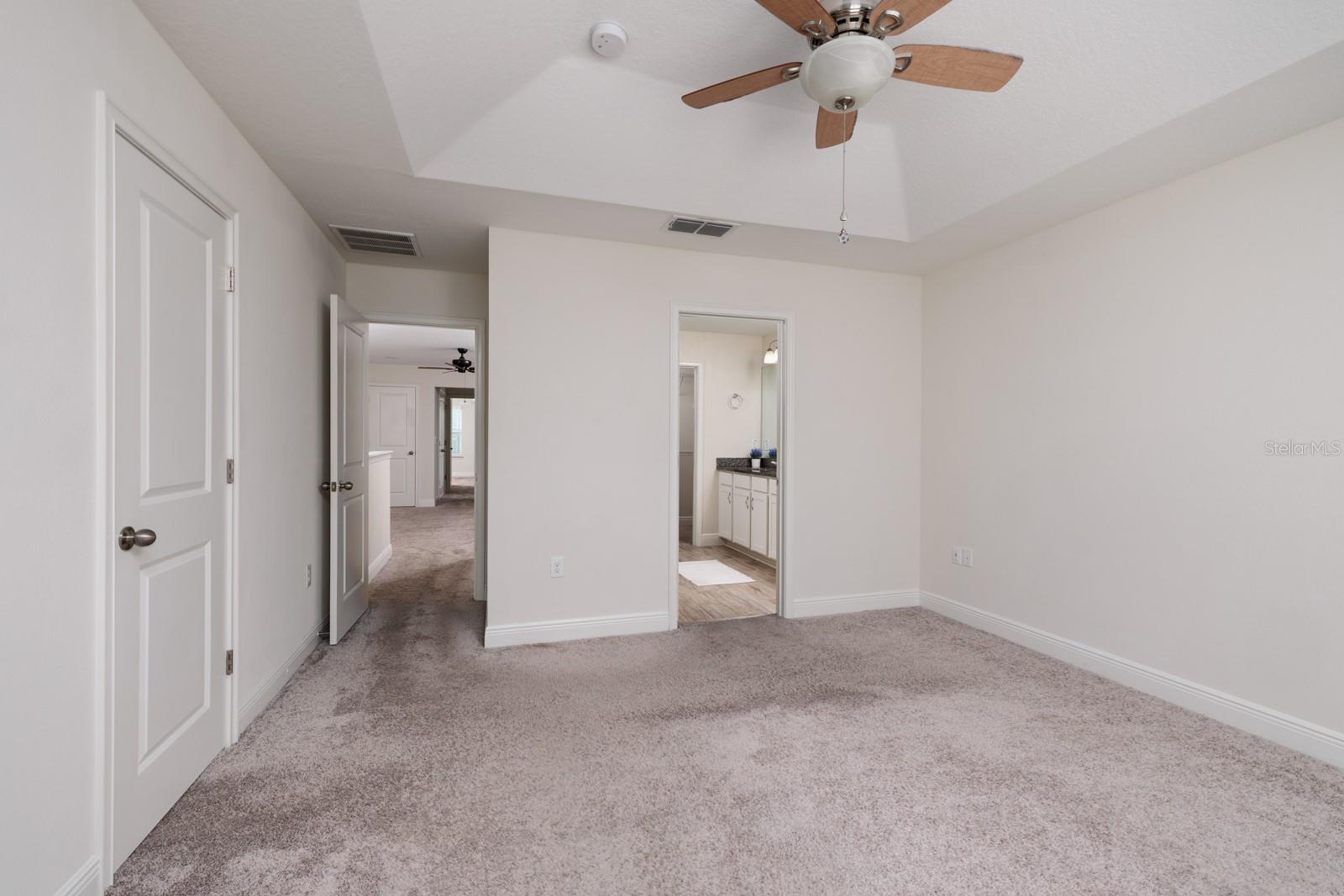 Primary Bedroom with "His and Her" closets on the left and en suite bathroom.