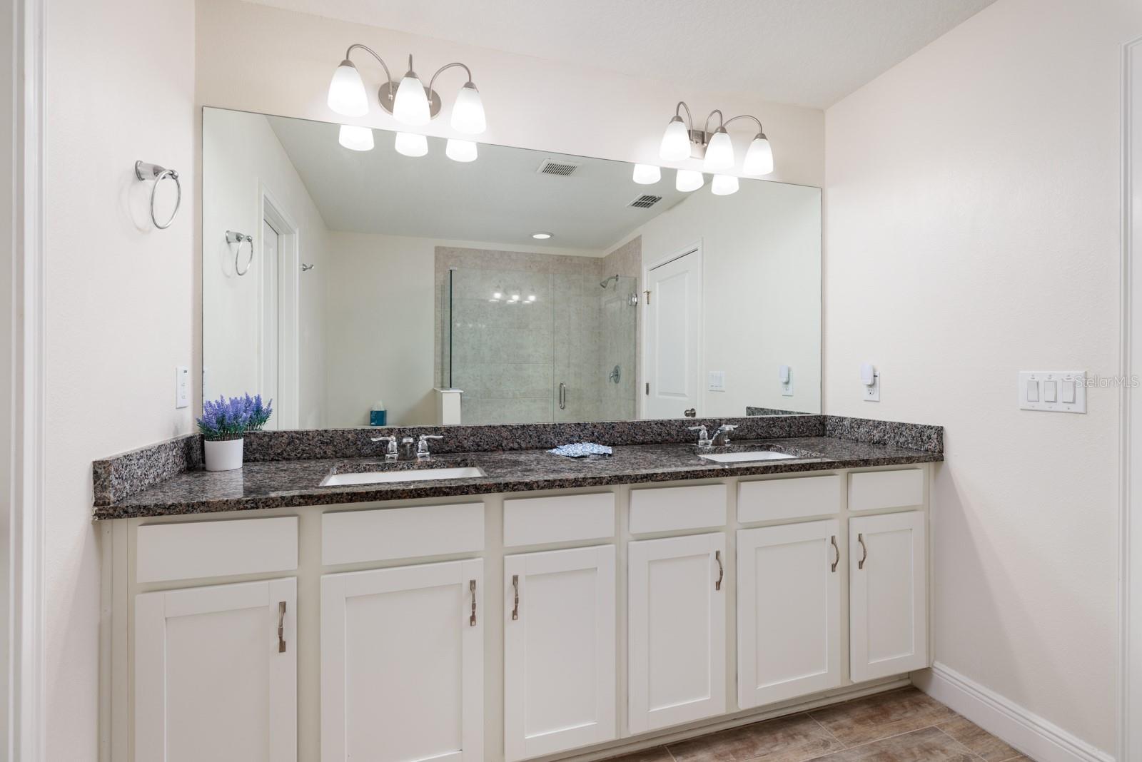 Primary Bathroom with dual sinks and granite countertop.