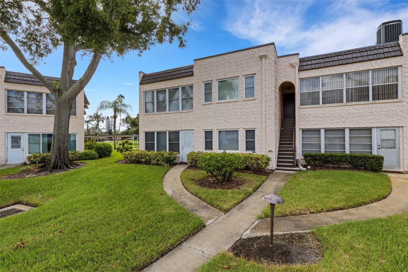 Rear of Unit With Stairs Down to Sidewalk Leading to Pool and Clubhouse.