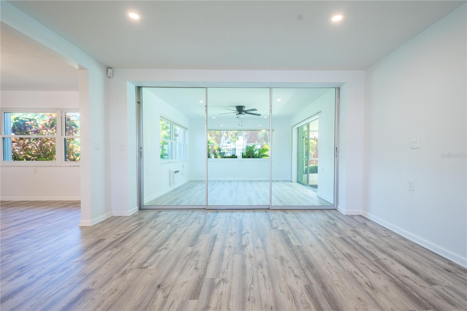 The living room features a wall of sliding glass doors that open to the year-round Florida room with dedicated A/C and ceiling fan for year round enjoyment.