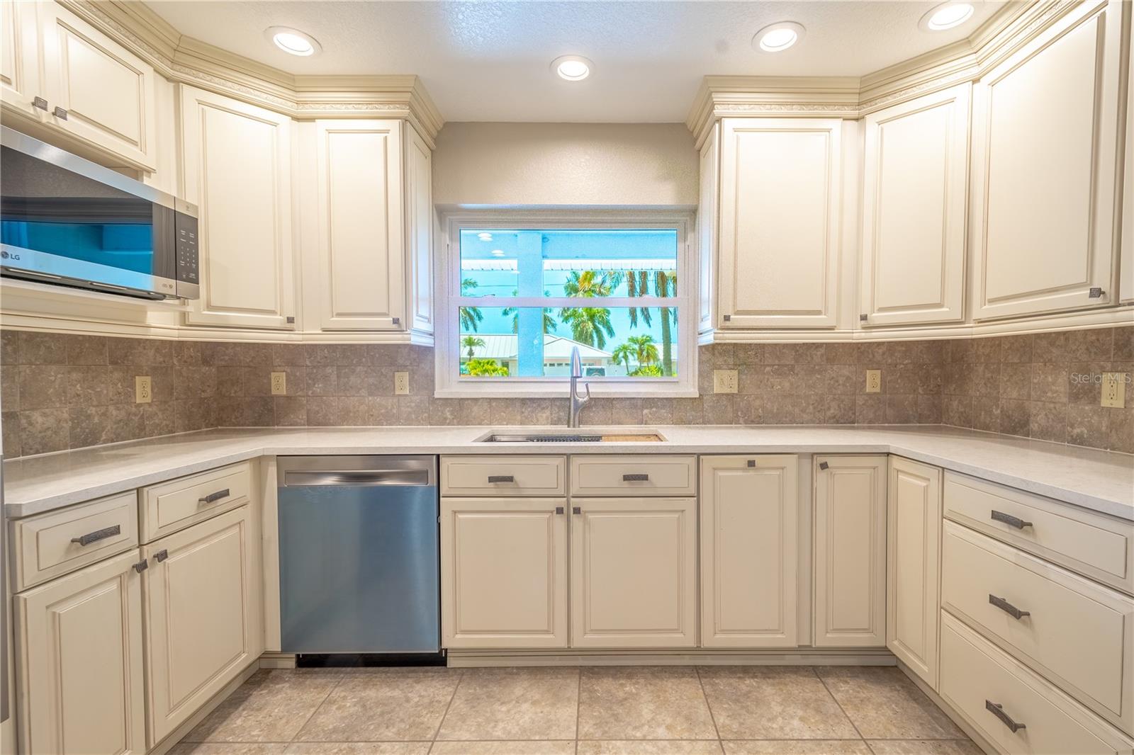 Recessed lighting casts a warm glow on the stunning alabaster cabinets, highlighting the exquisite molding detail.