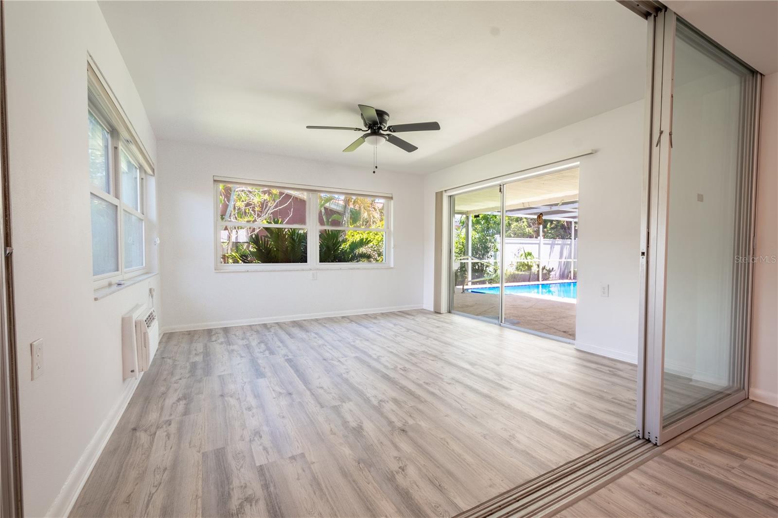 The Florida room has two large windows and sliding glass doors that open to the screen in lanai and pool.