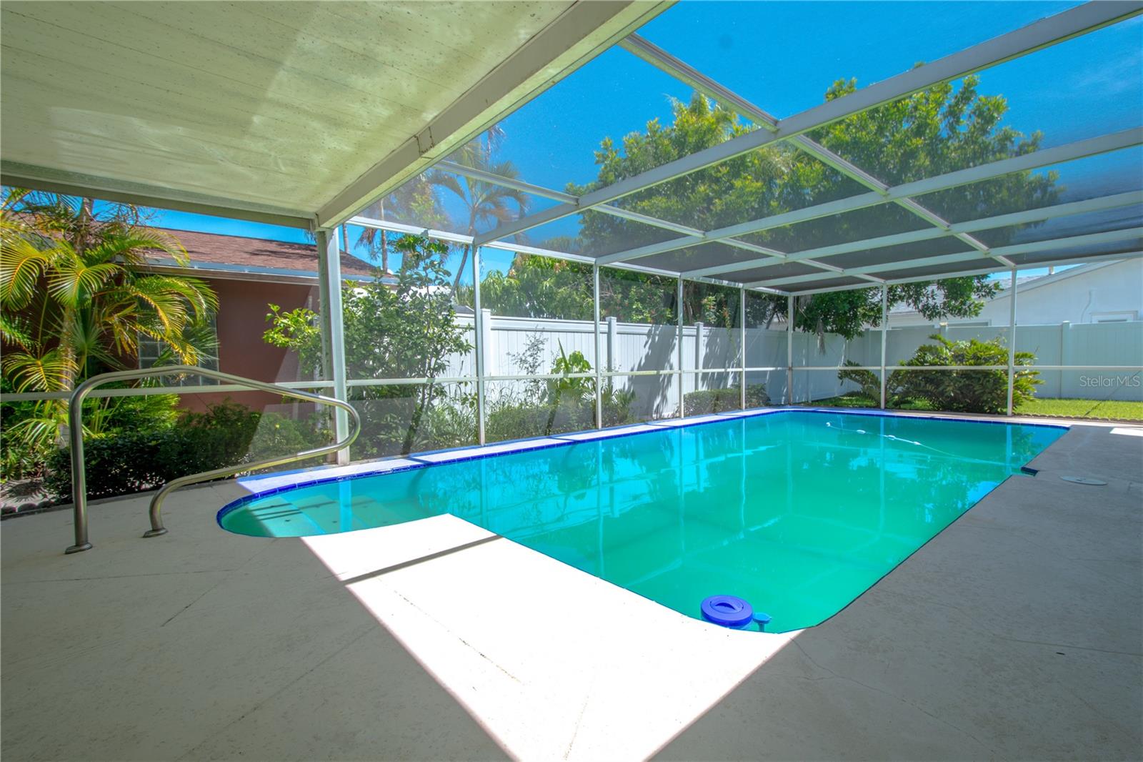 The screened-in, partially covered lanai provides a perfect space for enjoying the outdoors, whether rain or shine, with ample room for seating and relaxation