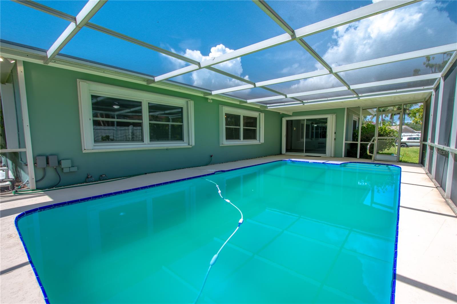 The in-ground, screened-in pool creates a serene retreat, allowing for year-round enjoyment with protection from the elements and a seamless connection to the outdoor living space