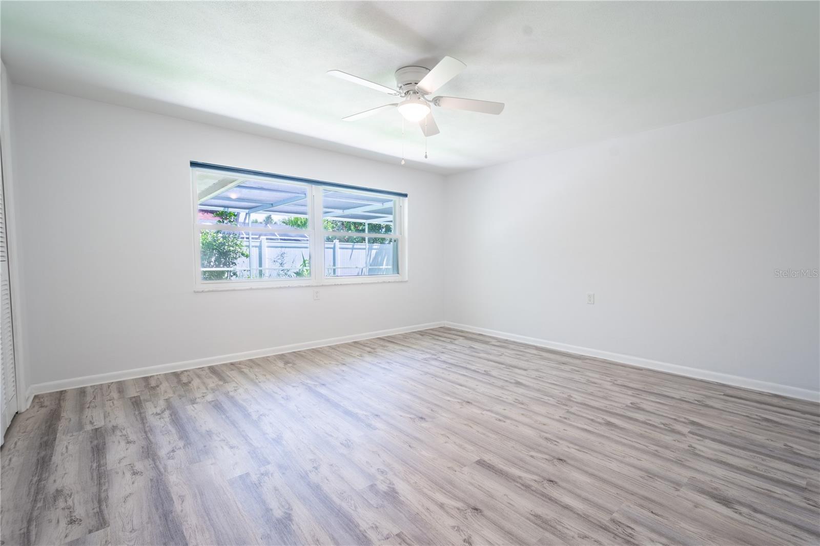 Bedroom 2 features luxury vinyl flooring and a ceiling fan with light kit.