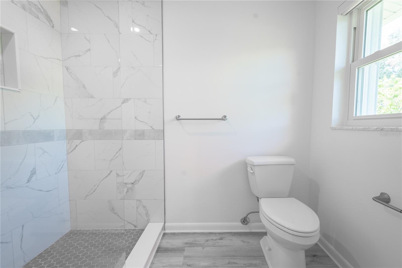 The primary bathroom features a glass enclosed, walk-in shower.