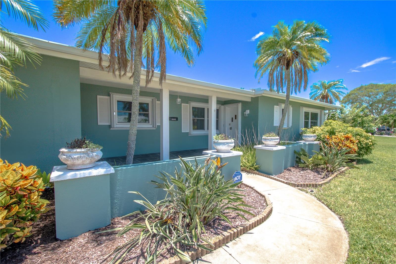 The covered front entry is flanked by two palm trees adding a tropical flare and curb appeal.