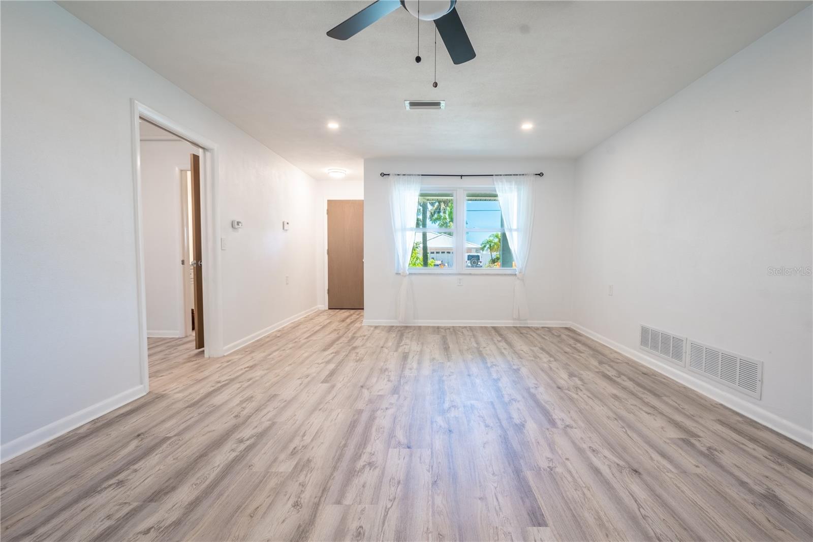 The living room is light and bright and features recessed lighting.