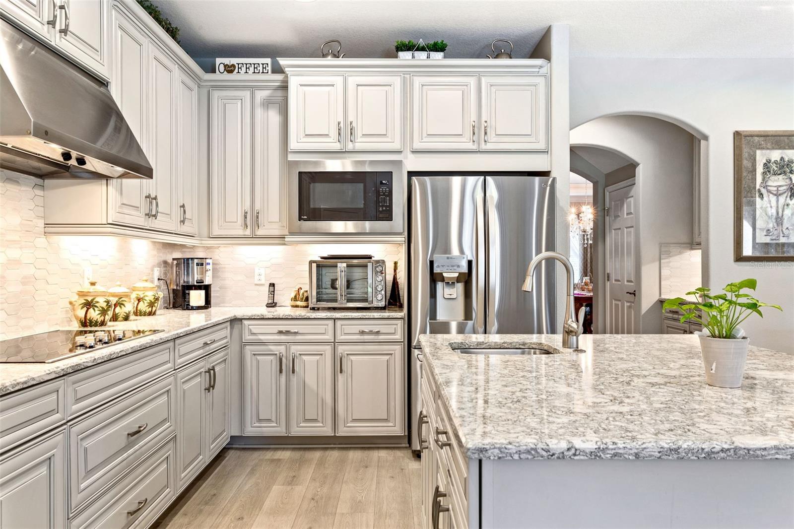 Your gourmet upgraded kitchen features stainless steel appliances, hooded cook top, upgraded cabinetry, & two prep sinks.