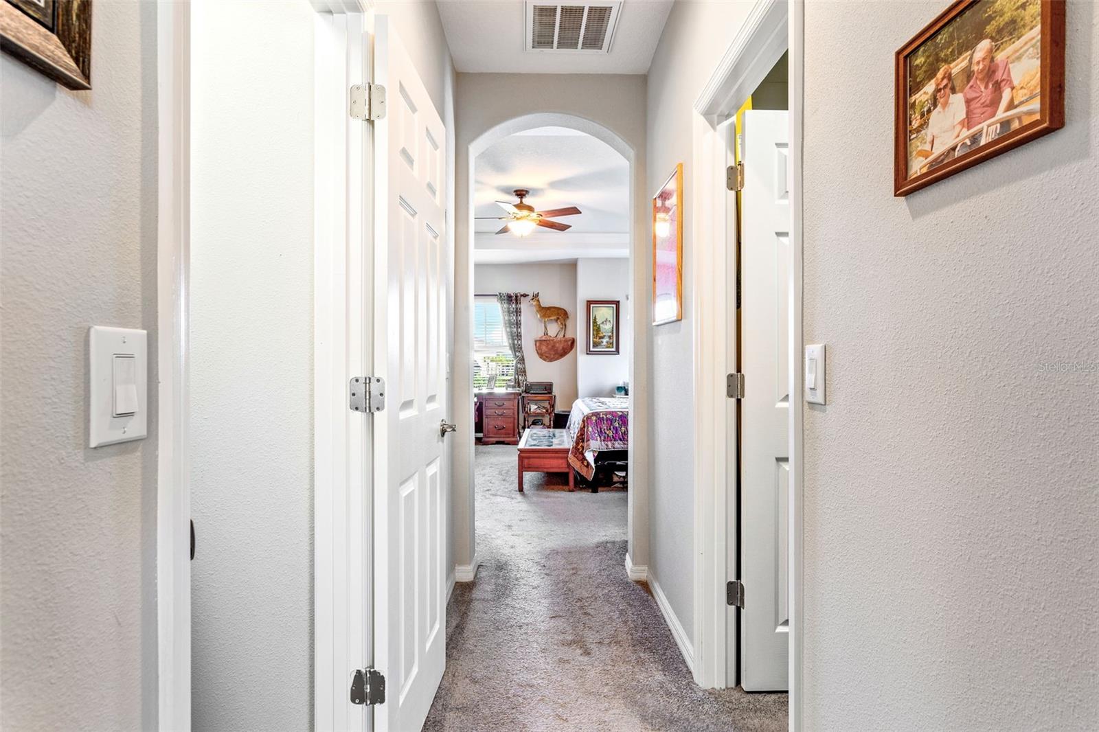 Hallway from primary suite to two walk in closets & ensuite bath.