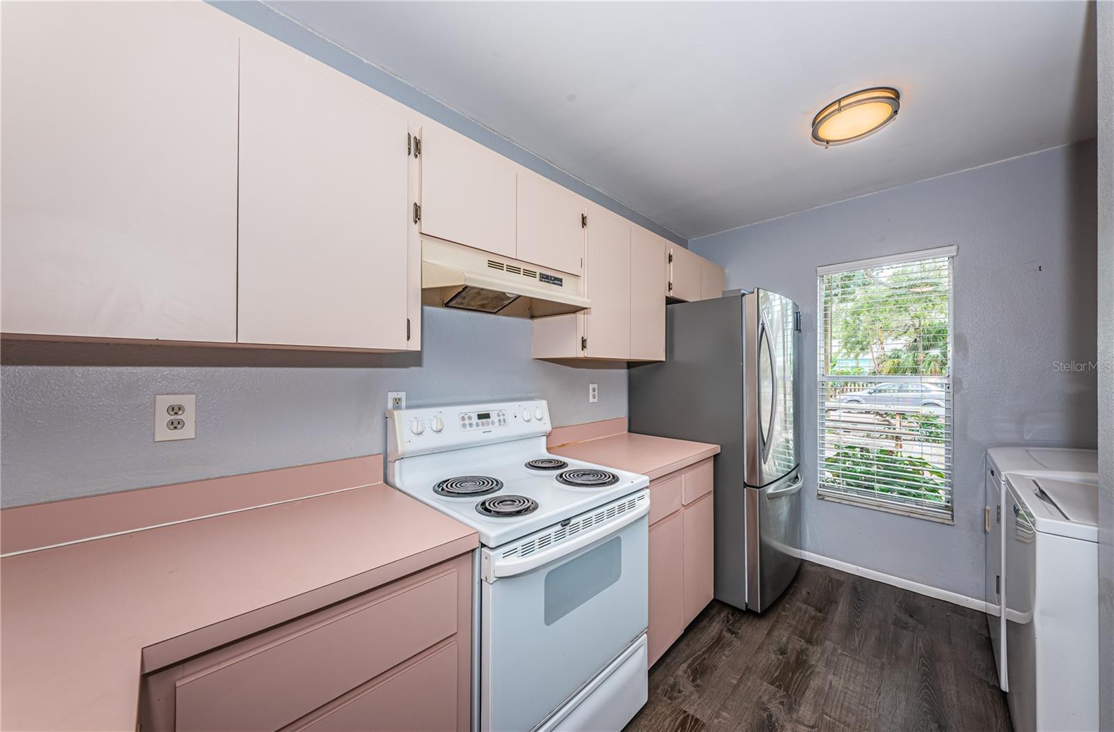 View in kitchen of refrigerator, laundry and front window