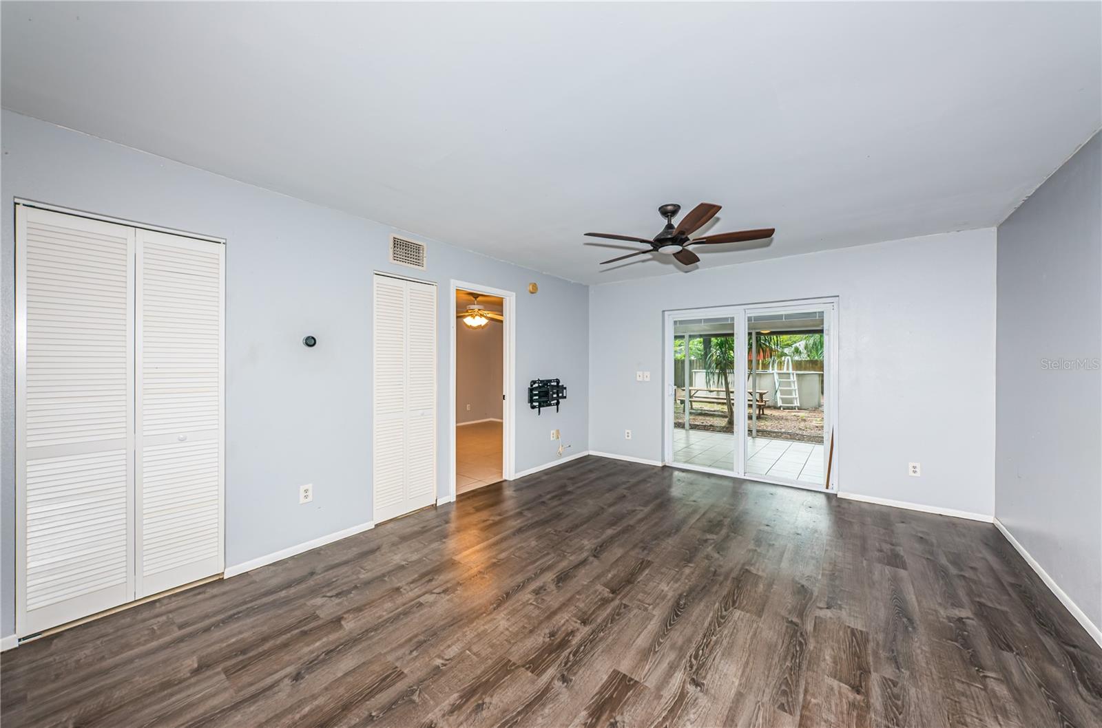 From the dining area, a view of the primary bedroom entry and sliding glass doors to the screened patio