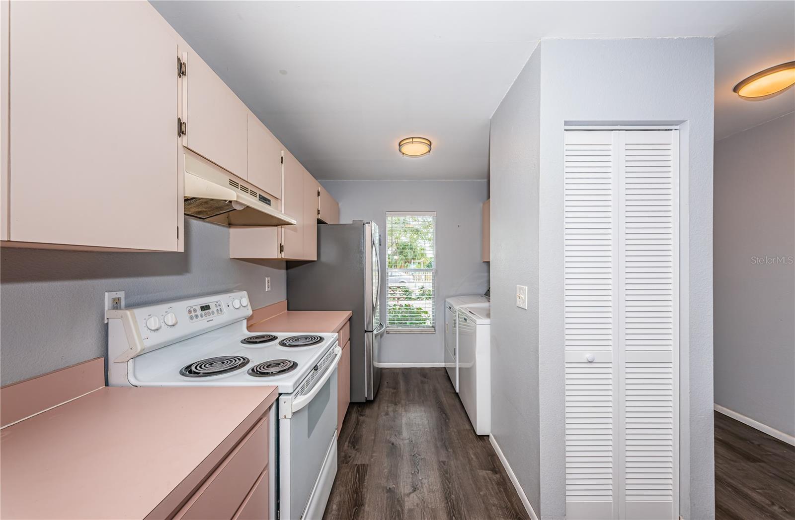 View in kitchen of refrigerator, laundry and front window