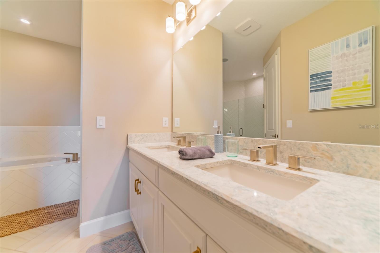 Primary bathroom with dual vanities and upgraded quartz counter