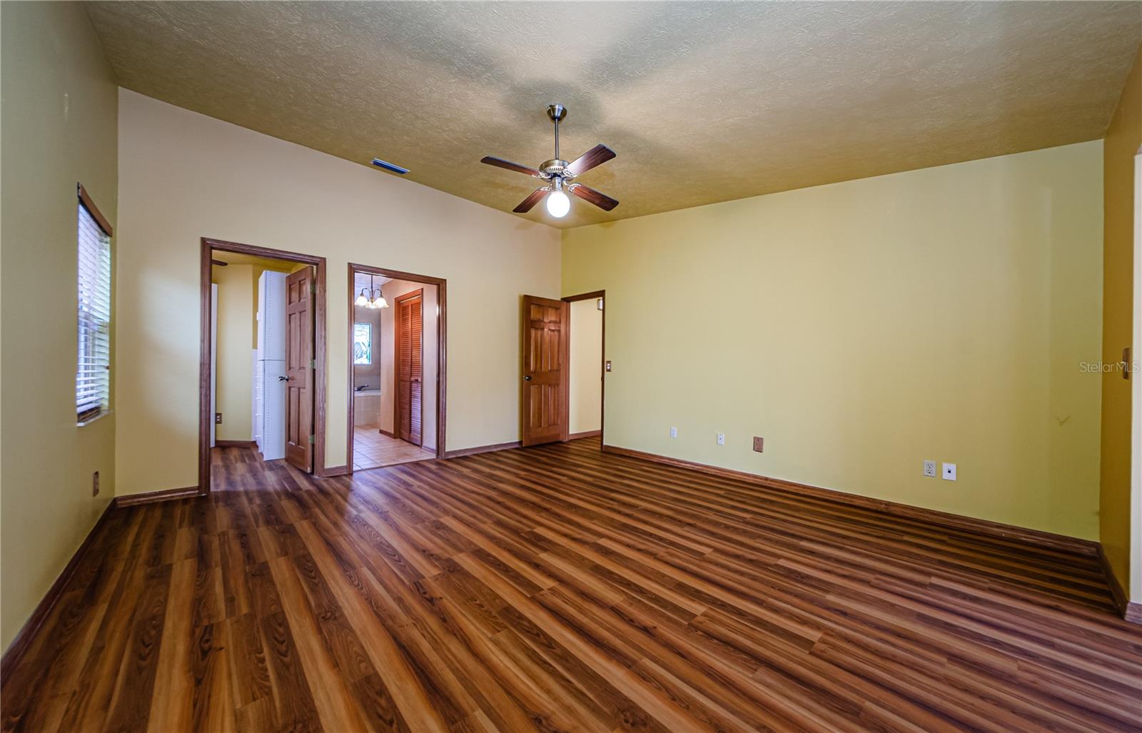 Primary bedroom showing additional den/office space and bathroom