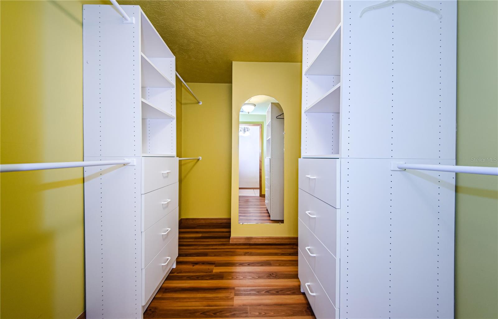 Primary bedroom walk in closet with built in storage