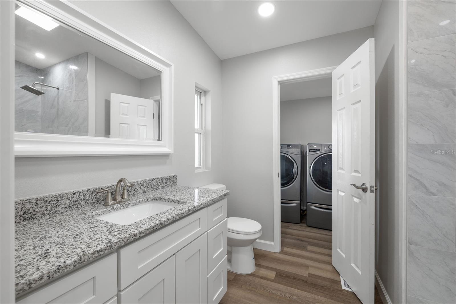 Primary bathroom also features a pass through door toward the laundry and kitchen area.