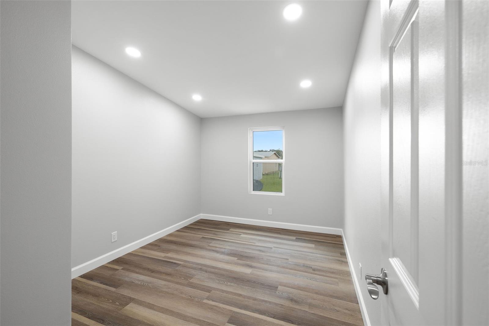 Nice size secondary bedroom with recessed lighting, luxury flooring, new door!