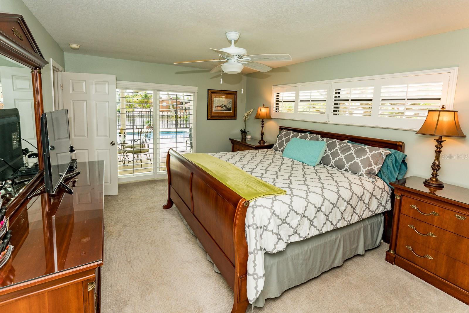 Primary bedroom with slider to the lanai has ensuite bathroom and walk-in closet.