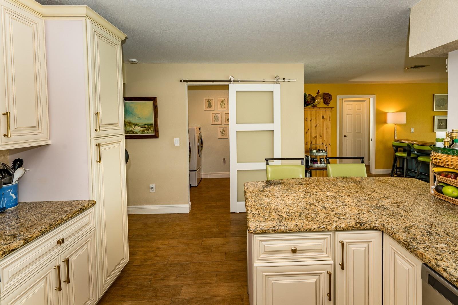 The glass barn door next to the kitchen conceals a convenient laundry room with storage and folding counter.  Washer & Dryer do not convey.