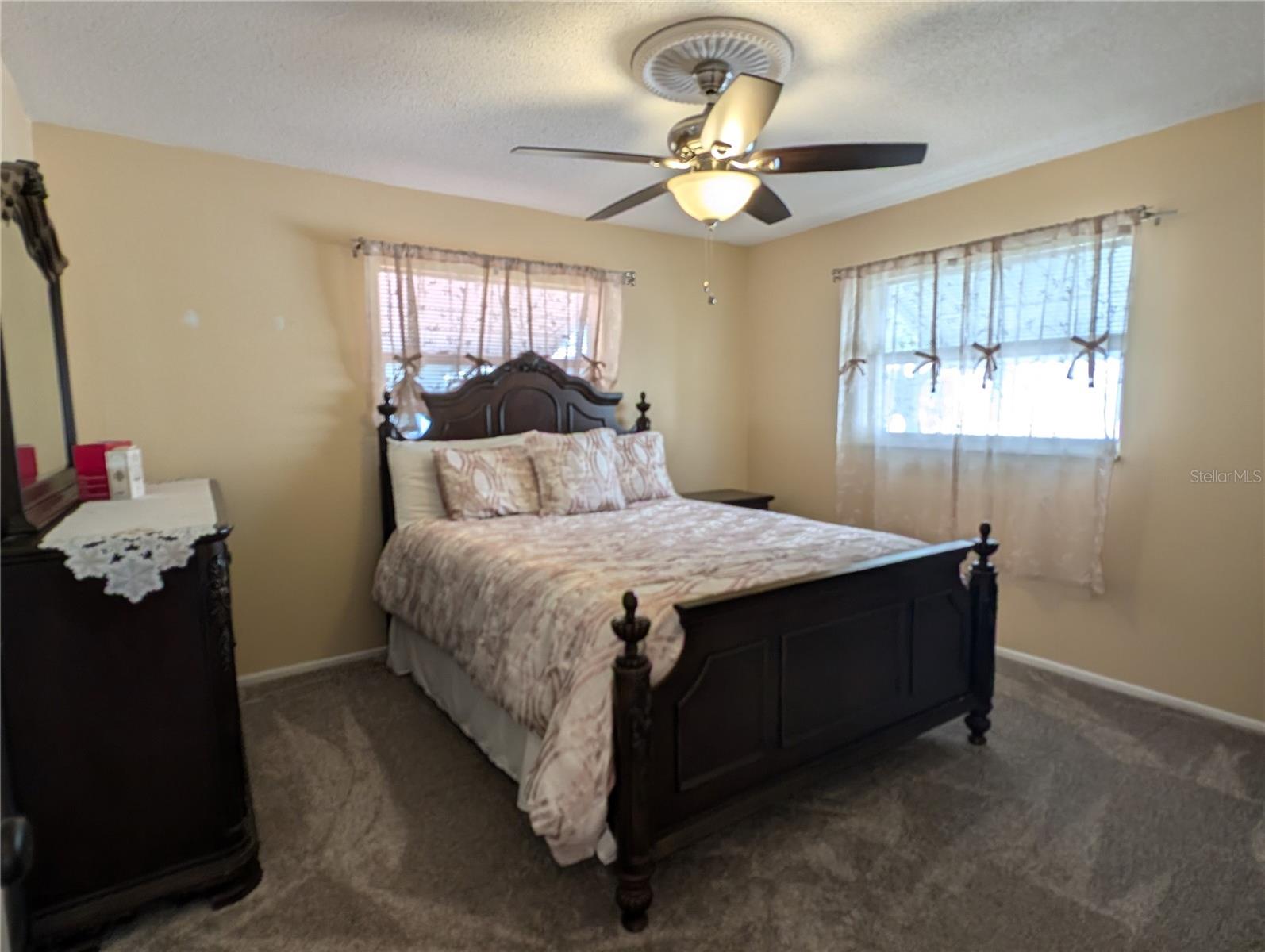 Primary bedroom also has new carpeting, ceiling fan with light on a decorative medallion and two windows to provide lots of natural light and great cross ventilation.