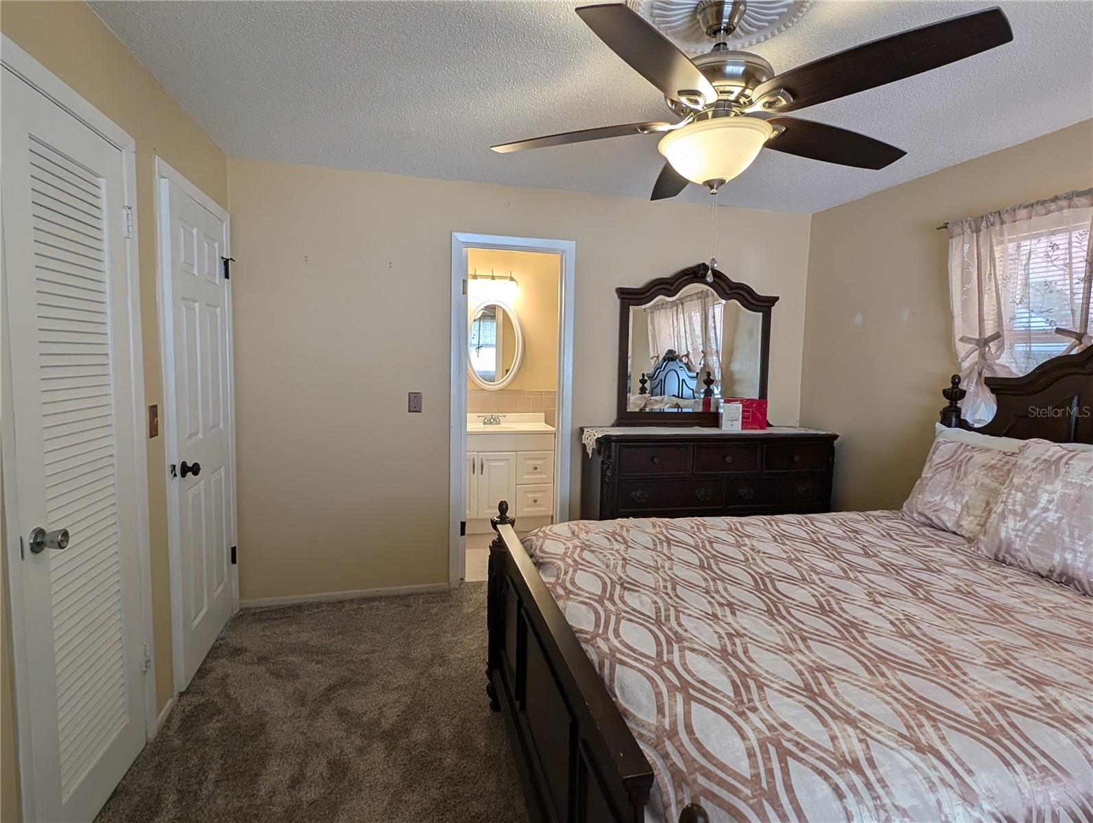 View of primary bedroom closet, ensuite bath and entry door.