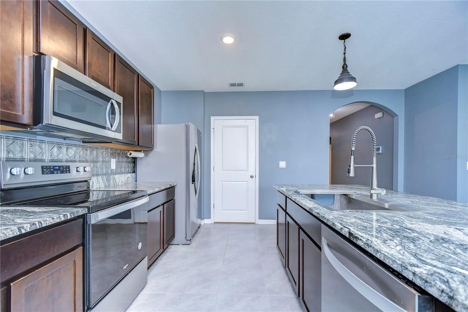 Wood cabinets, stunning granite countertops, stainless appliances, custom tile backsplash and generous pantry!