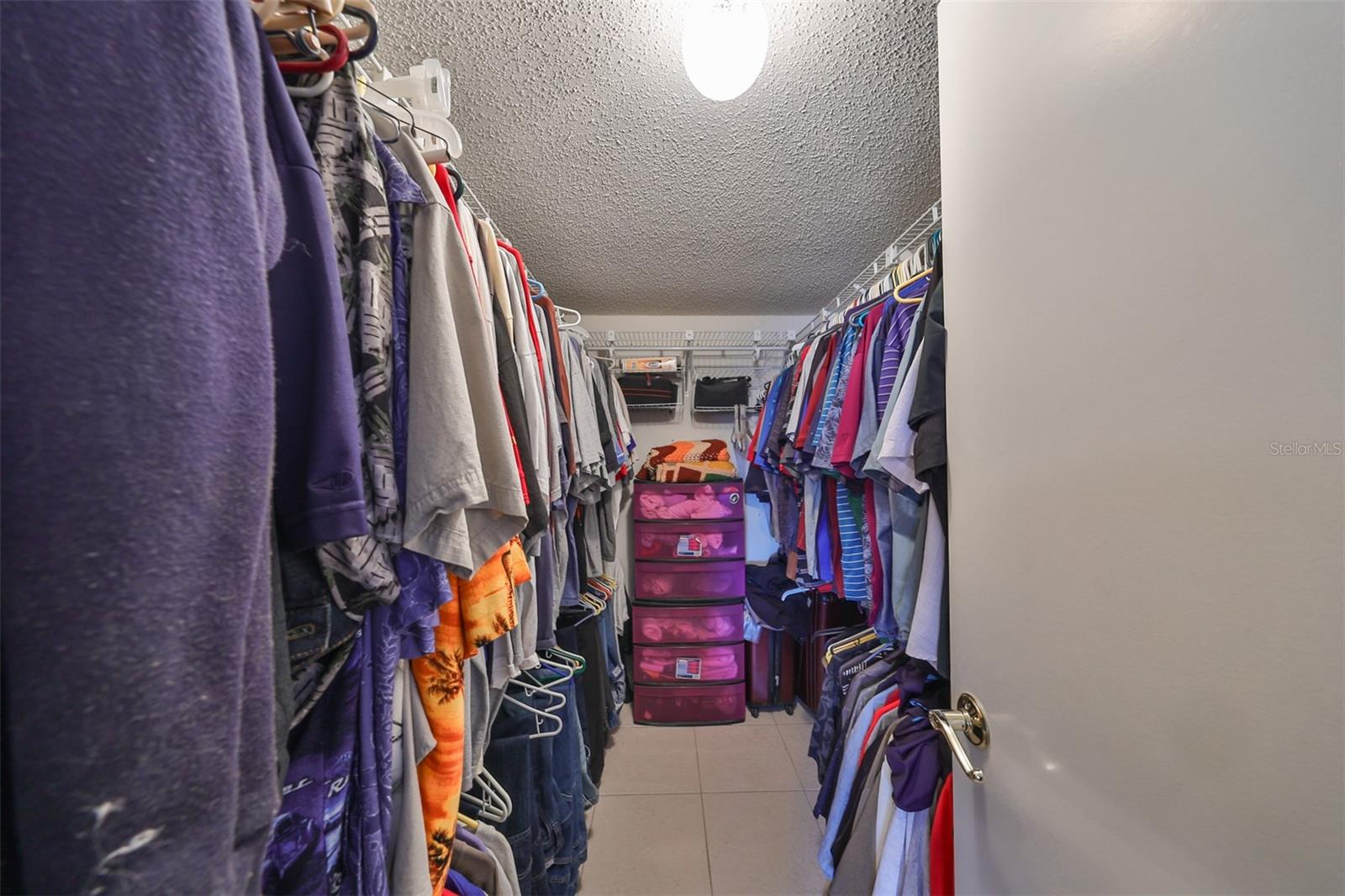 This walk in closet is almost another room, due to its size.