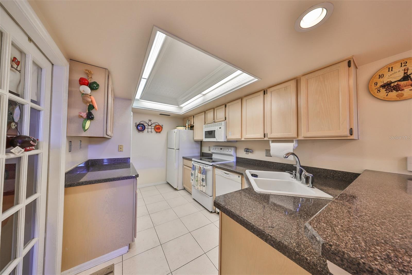 The kitchen is spacious and bright with a beautiful ceiling enhancement.