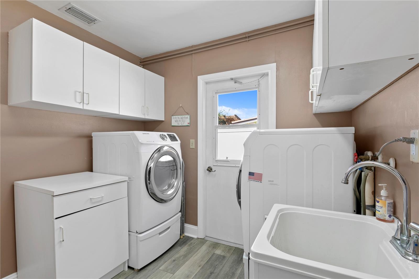 spacious laundry with passage to garage and side yard