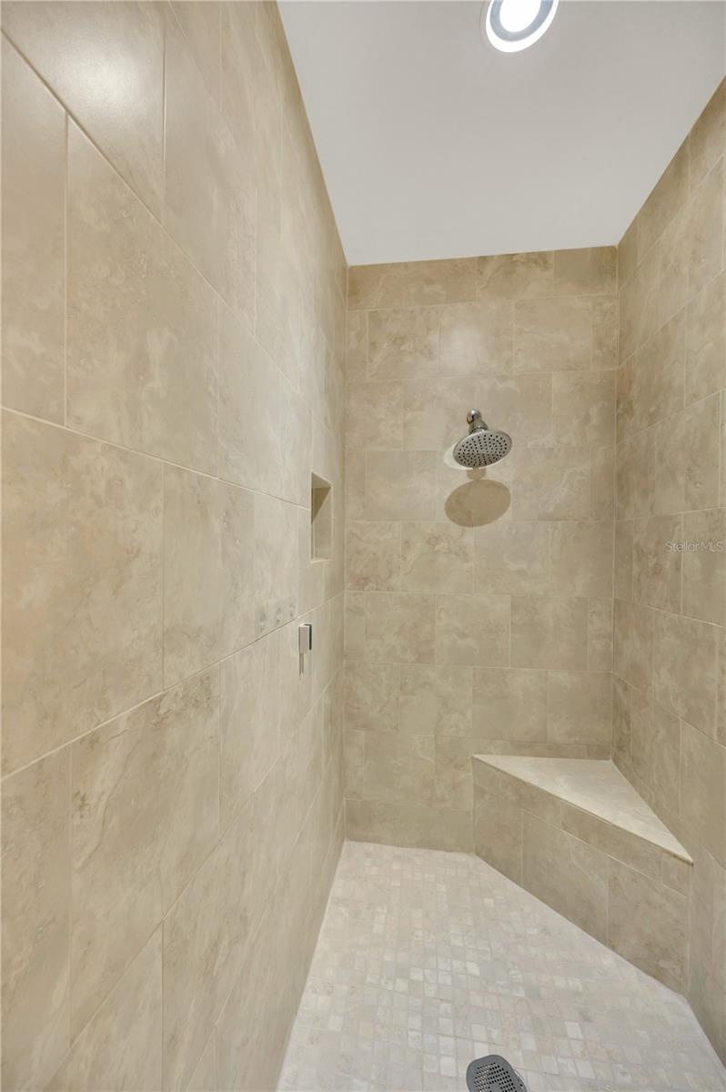 The ensuite bath boasts a huge walk-in closet and this spacious walk-in shower with bench.