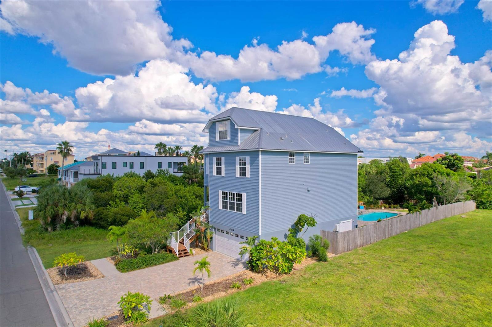 The ground floor offers a spacious oversized 2 car garage, enclosed storage room/workshop and a spacious enclosed lanai overlooking a magnificent backyard with pool/spa and private dock on canal.