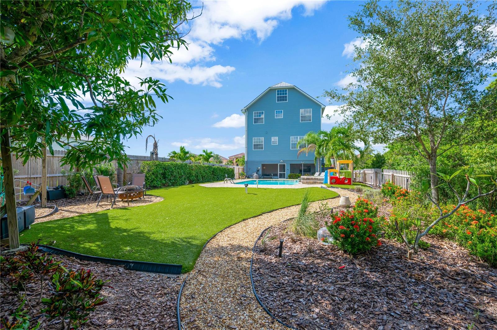 View of back of home and yard from pathway to private dock.