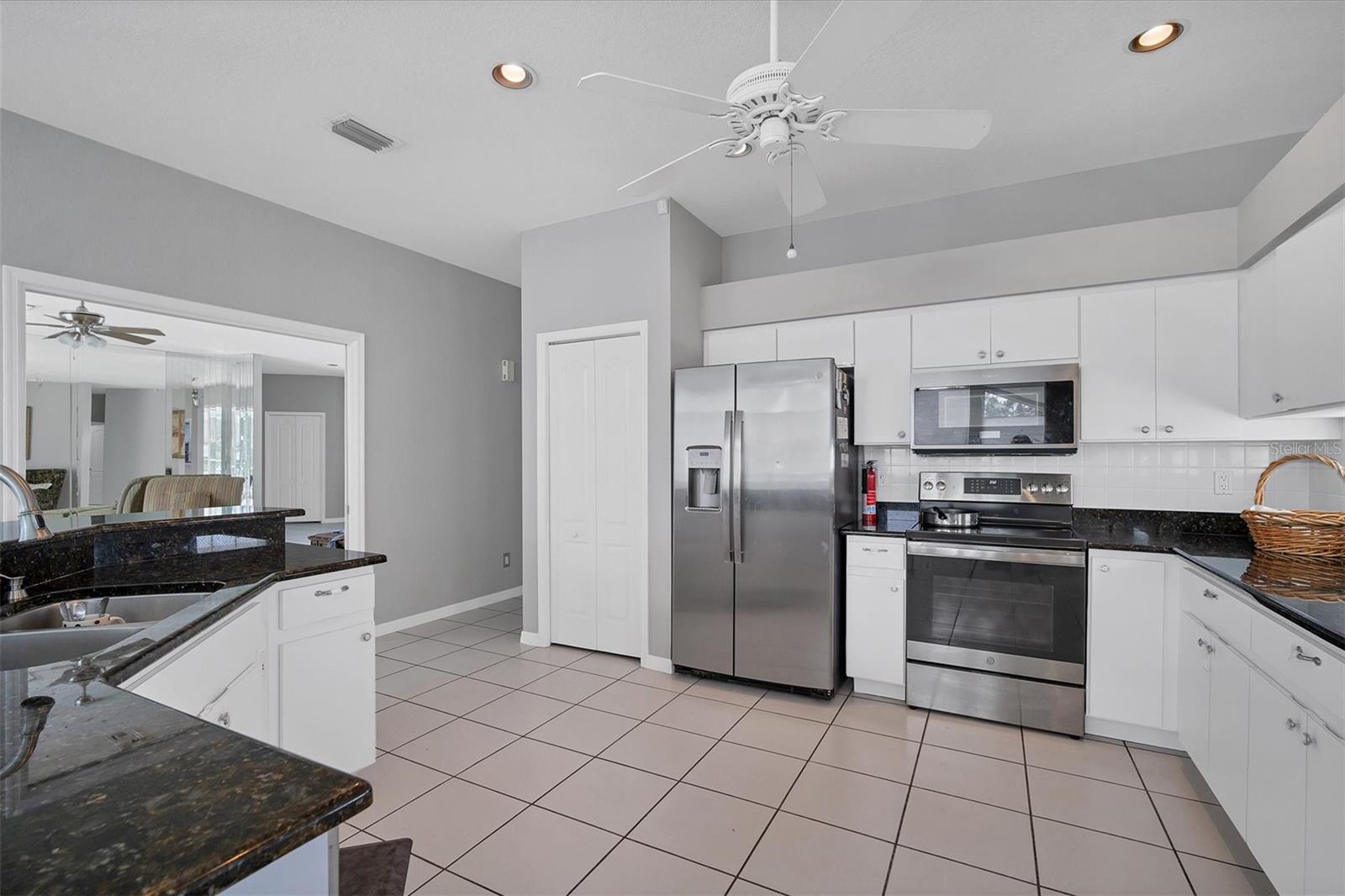 Kitchen has spacious pantry, and stainless-steel appliances including a side-by-side refrigerator, glass top range, newer microwave.