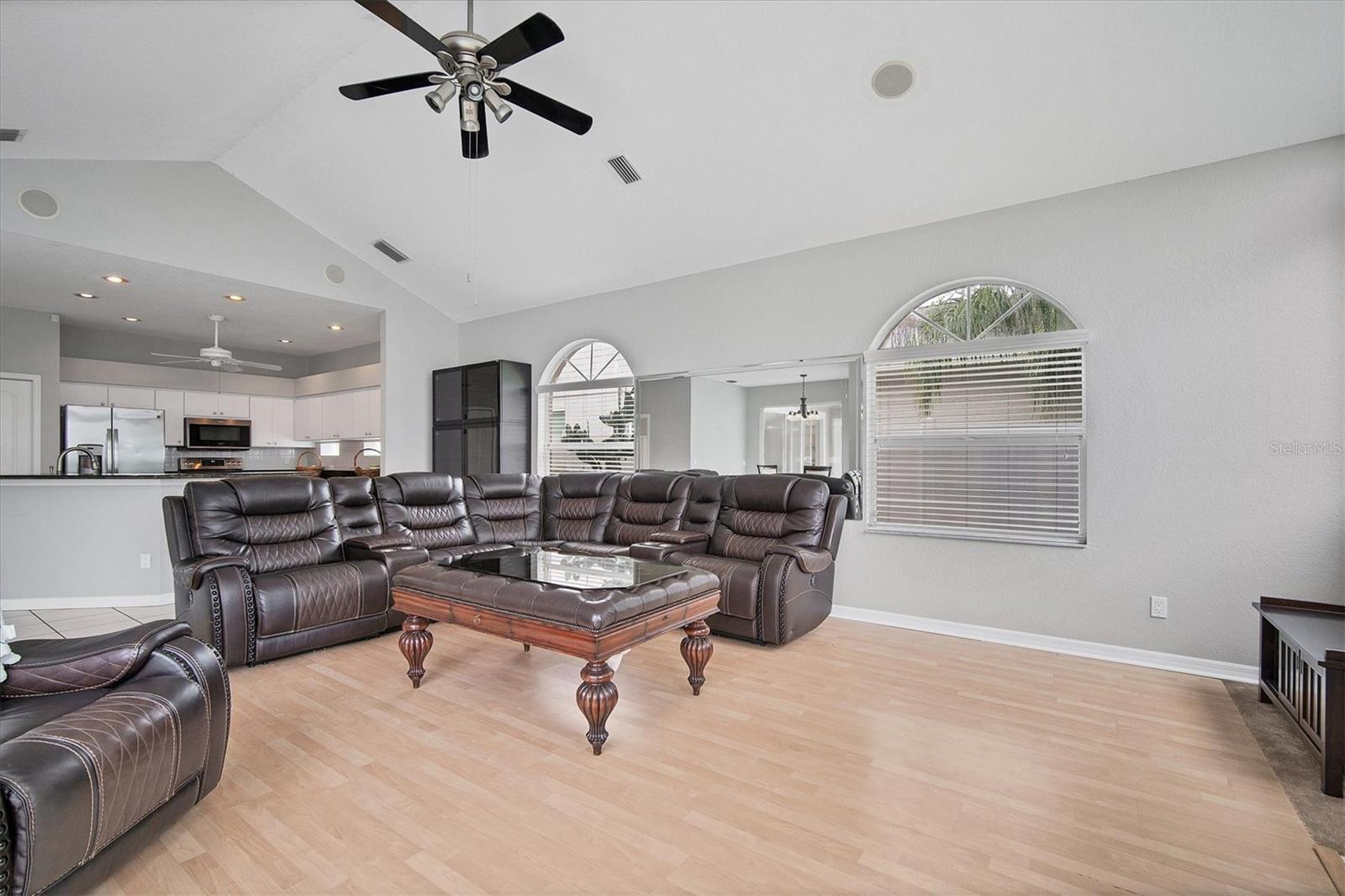 View into kitchen from family room.  Two large windows on each side of mirror.  Black wall cabinet is attached to wall and will convey.