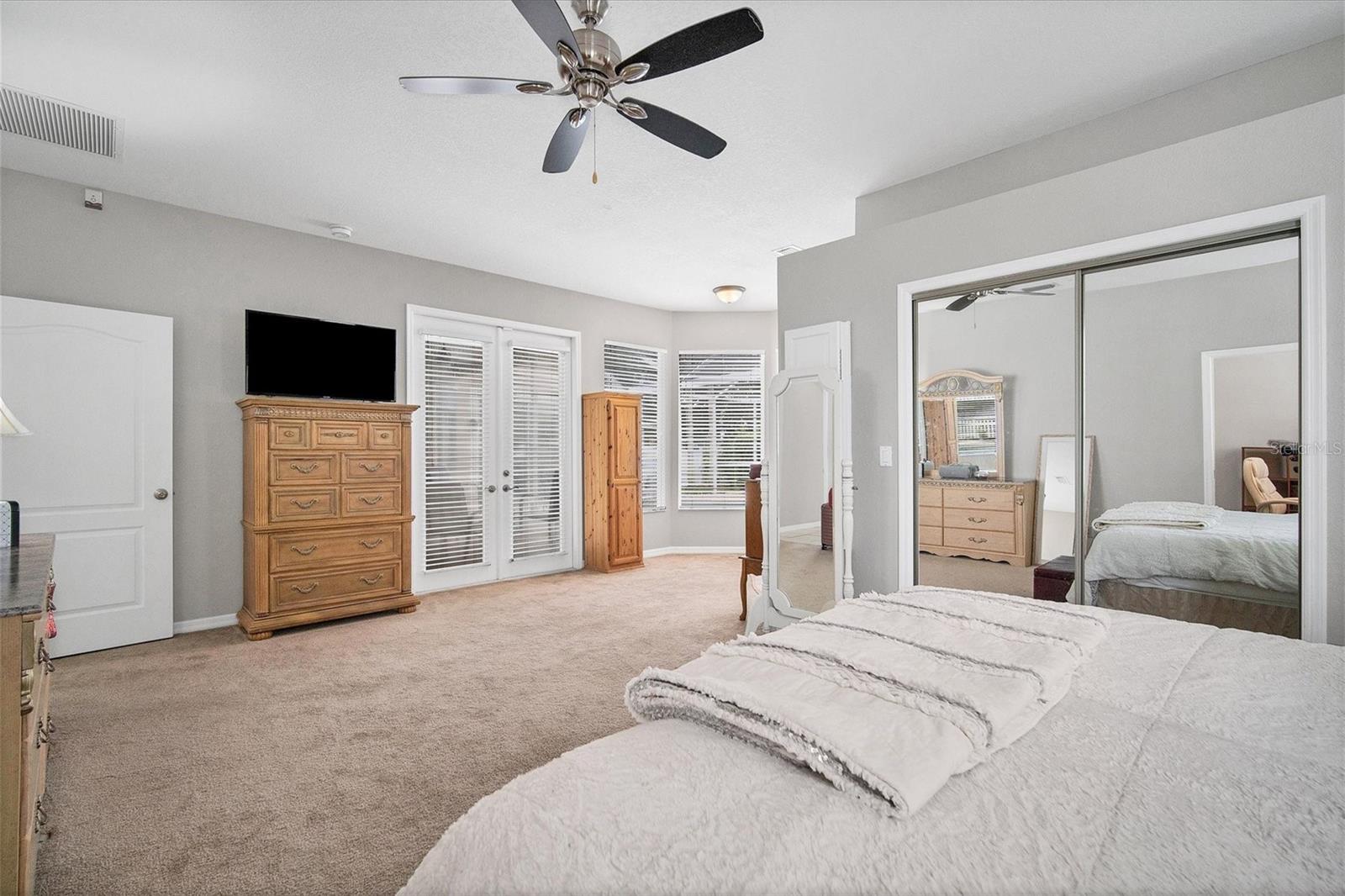 View of master suite to sitting area.  Spacious walk-in closet behind double mirrored doors.