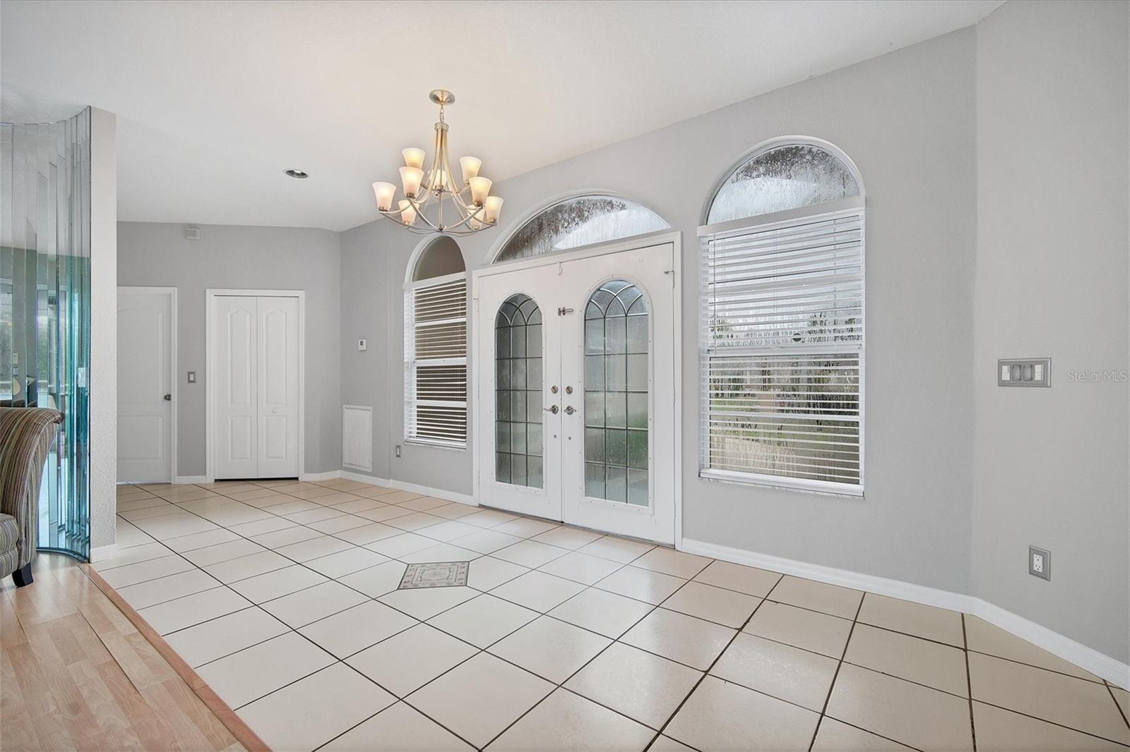 Stately front entry into open foyer.  Storage closet and laundry room hall behind closed doors on left.