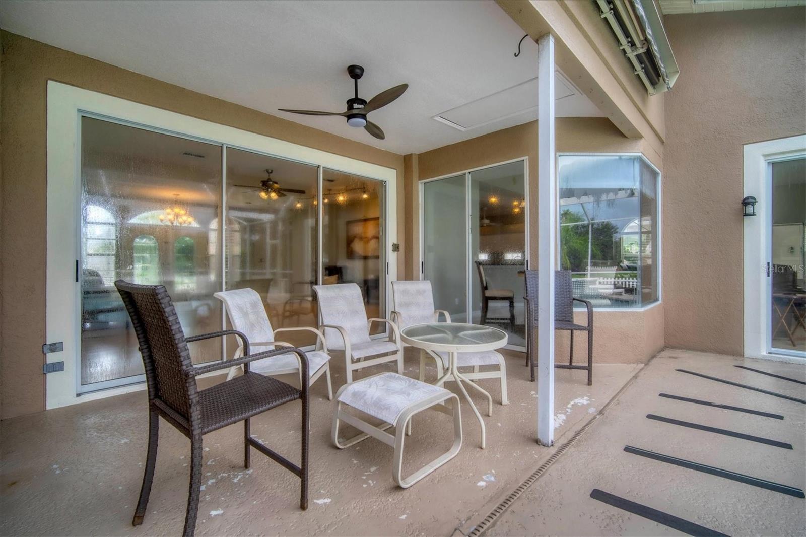 Covered seating on back patio with view into front living area and entry through triple sliders.  Double sliders lead into dinette.