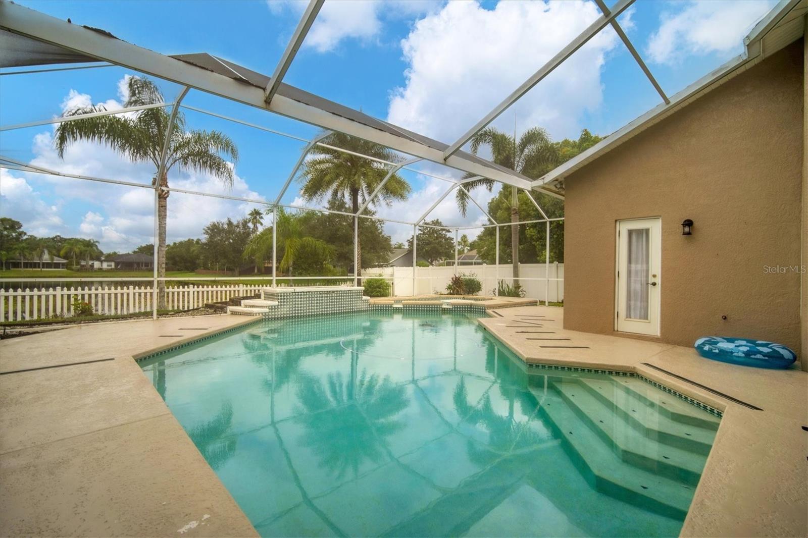 Large pool/spa with planter box under spacious screened lanai.  Door leads into master bathroom.